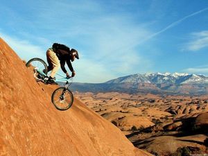 A guy riding a mountain bike on the mountains
